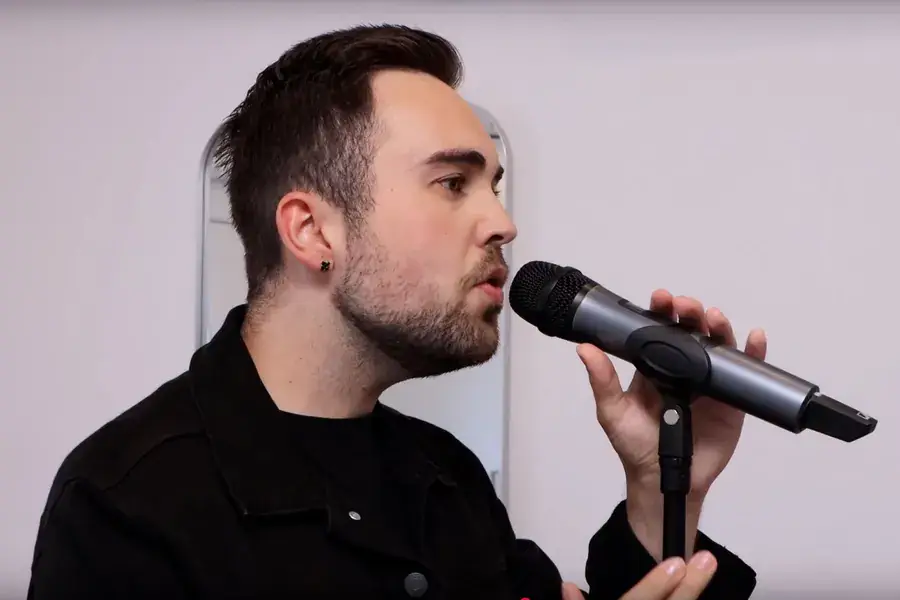 Janis Eric Thommen singt ins Mikrofon während einer Gesangslektion